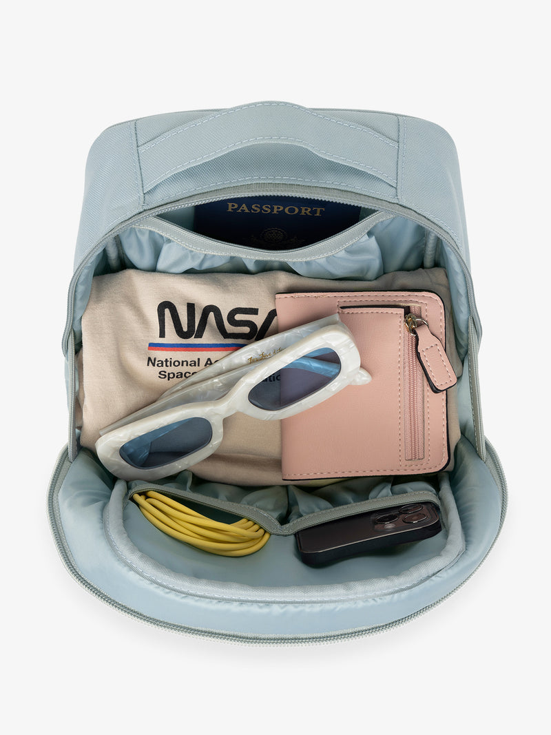 CALPAK Everything Cube in blue Bluebell with various items inside such as sunglasses, wallet, phone, and phone charger