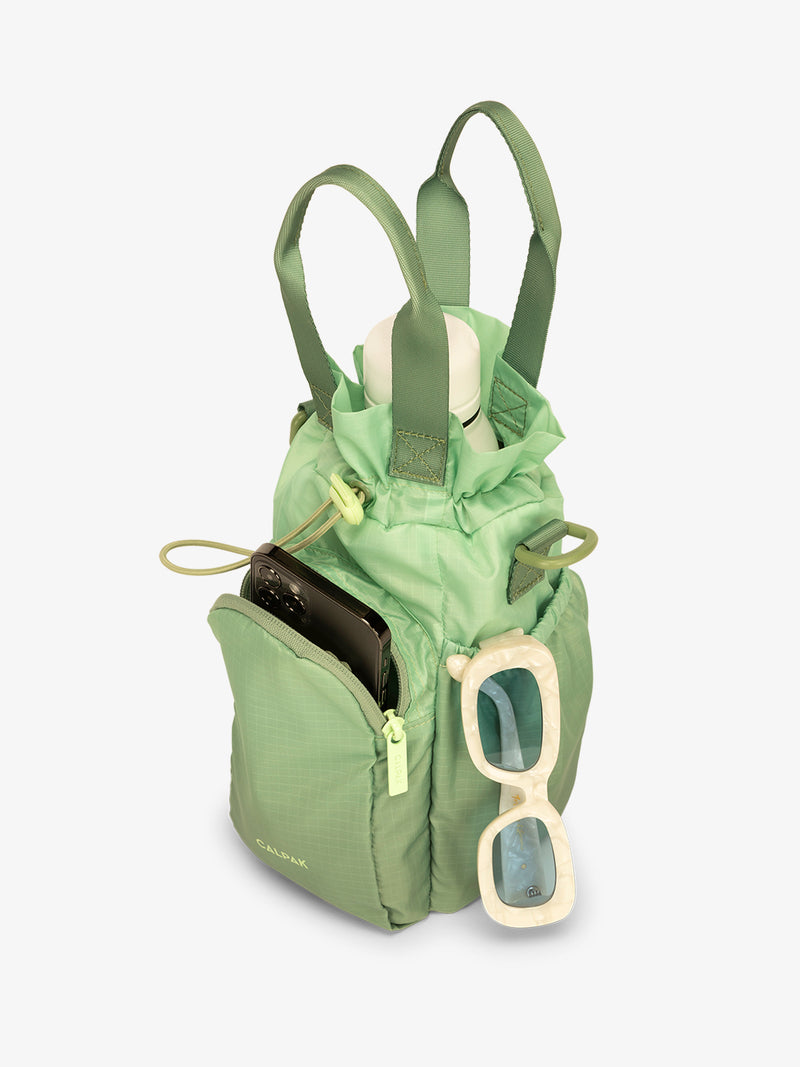 CALPAK Water Bottle Holder in green ombre Matcha with use of front phone pocket, side pocket with sunglasses and water bottle in main compartment