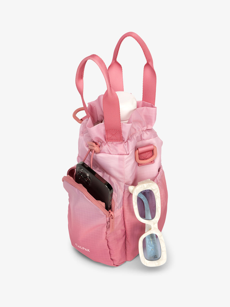 CALPAK Water Bottle Holder in pink ombre Tea Rose with use of front phone pocket, side pocket with sunglasses and water bottle in main compartment