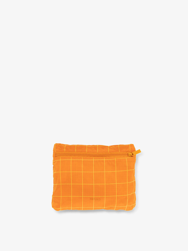 CALPAK Compakt foldable duffle bag for travel in orange grid print