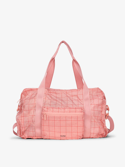 CALPAK Compakt duffel bag with removable crossbody strap and water resistant fabric in pink grid; KDB2001-PINK-GRID