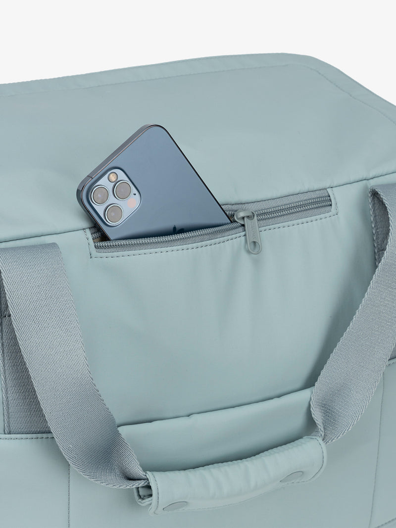 Zippered phone pocket of CALPAK Connect Laptop Duffel in bluebell blue