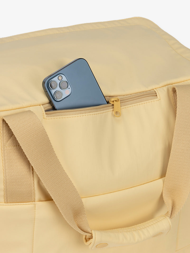 Zippered phone pocket of CALPAK Connect Laptop Duffel in sunshine yellow