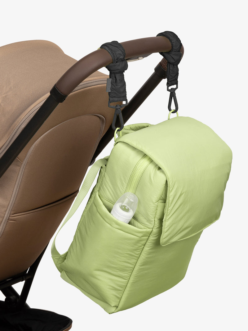 CALPAK Diaper Backpack in light green Lime with Black Stroller Straps attached to a brown stroller