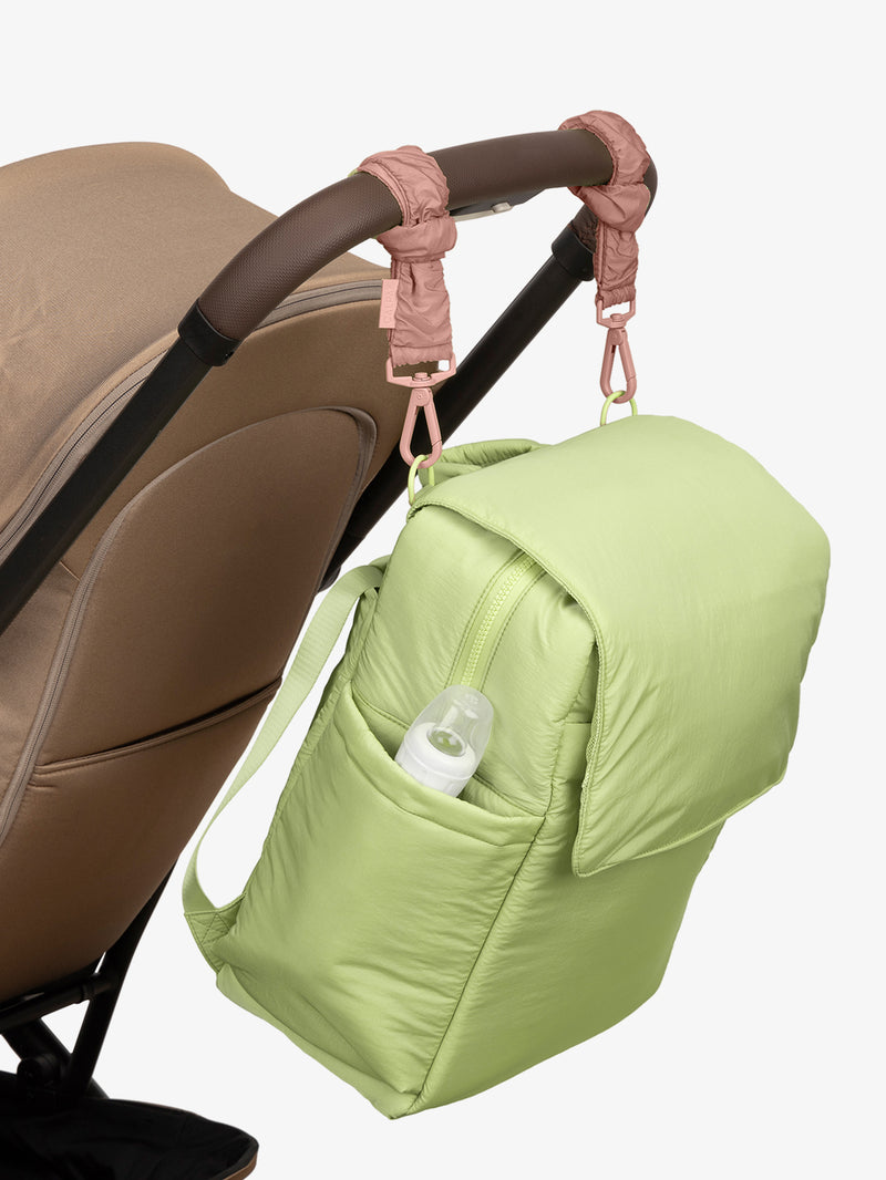 CALPAK Diaper Backpack in light green Lime with pink Peony Stroller Straps attached to a brown stroller