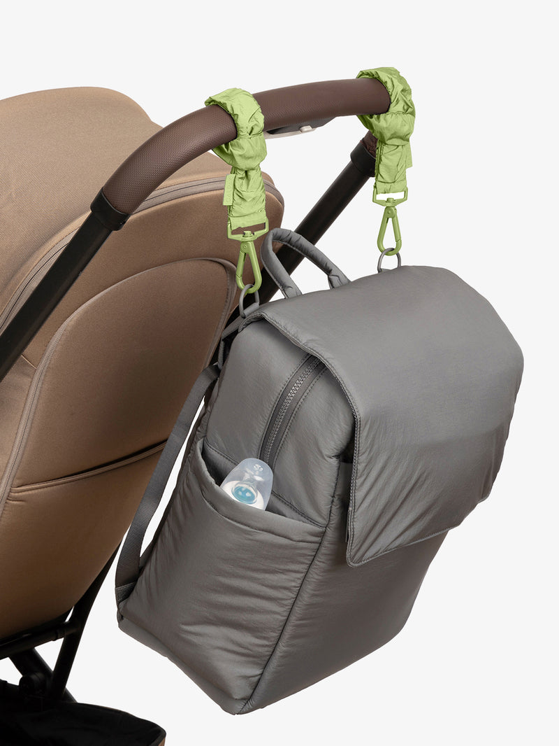 CALPAK Diaper Backpack in grey Slate with light green Lime Stroller Straps attached to a brown stroller