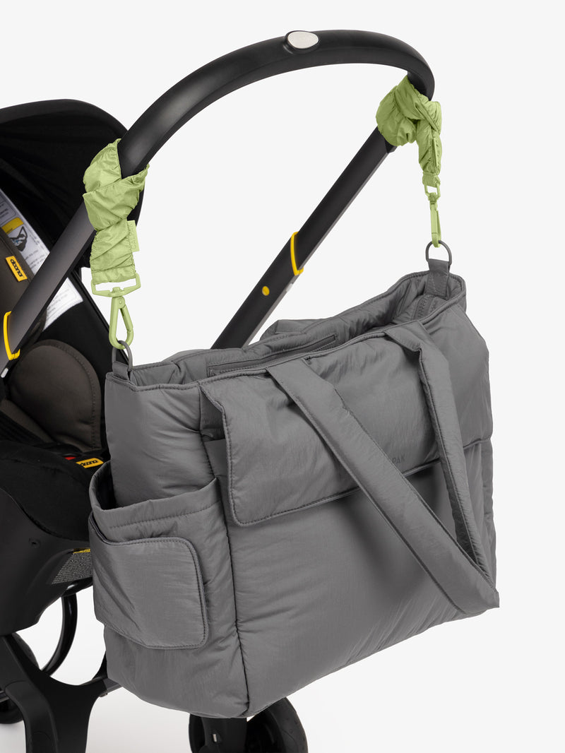 CALPAK Diaper Tote Bag in grey Slate with light green Lime Stroller Straps attached to a black stroller