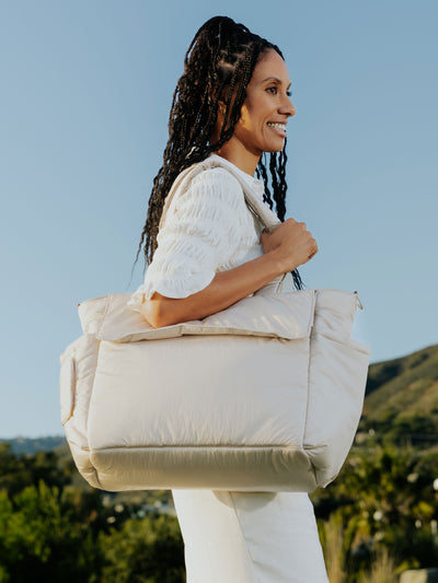 CALPAK Diaper Tote Bag with Stroller Straps attached to stroller handle in oatmeal beige; BTBB2401-OATMEAL