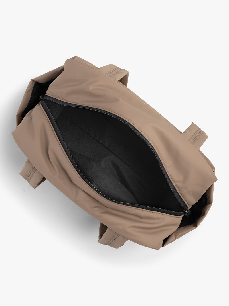 CALPAK Mini Duffel in brown Chocolate open interior view with puffy exterior, interior and exterior pockets, and padded shoulder straps
