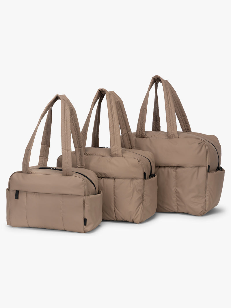 CALPAK Mini Duffel, Luka Duffel, and Luka Large Duffel in brown Chocolate front view with puffy exterior, interior and exterior pockets, and padded shoulder straps