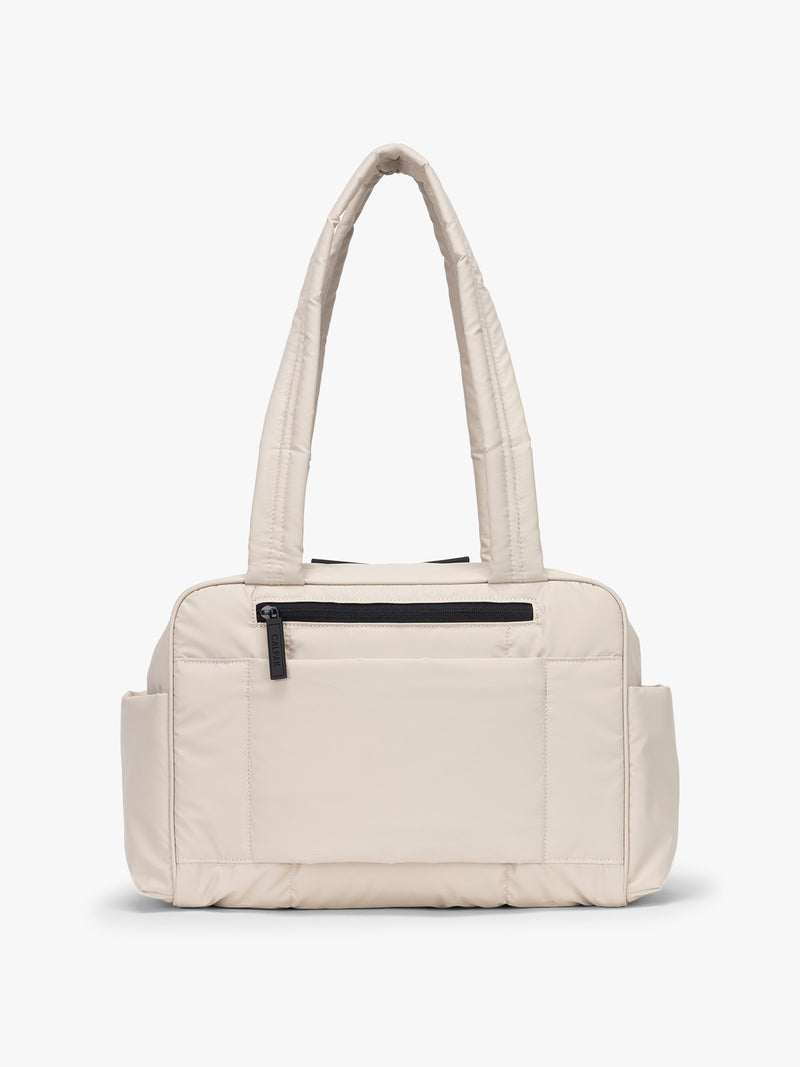 CALPAK Mini Duffel in white Oatmeal back view with zipper, puffy exterior, interior and exterior pockets, and padded shoulder straps