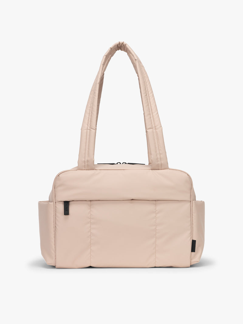 CALPAK Mini Duffel in light pink Rose Quartz with puffy exterior, interior and exterior pockets, and padded shoulder straps