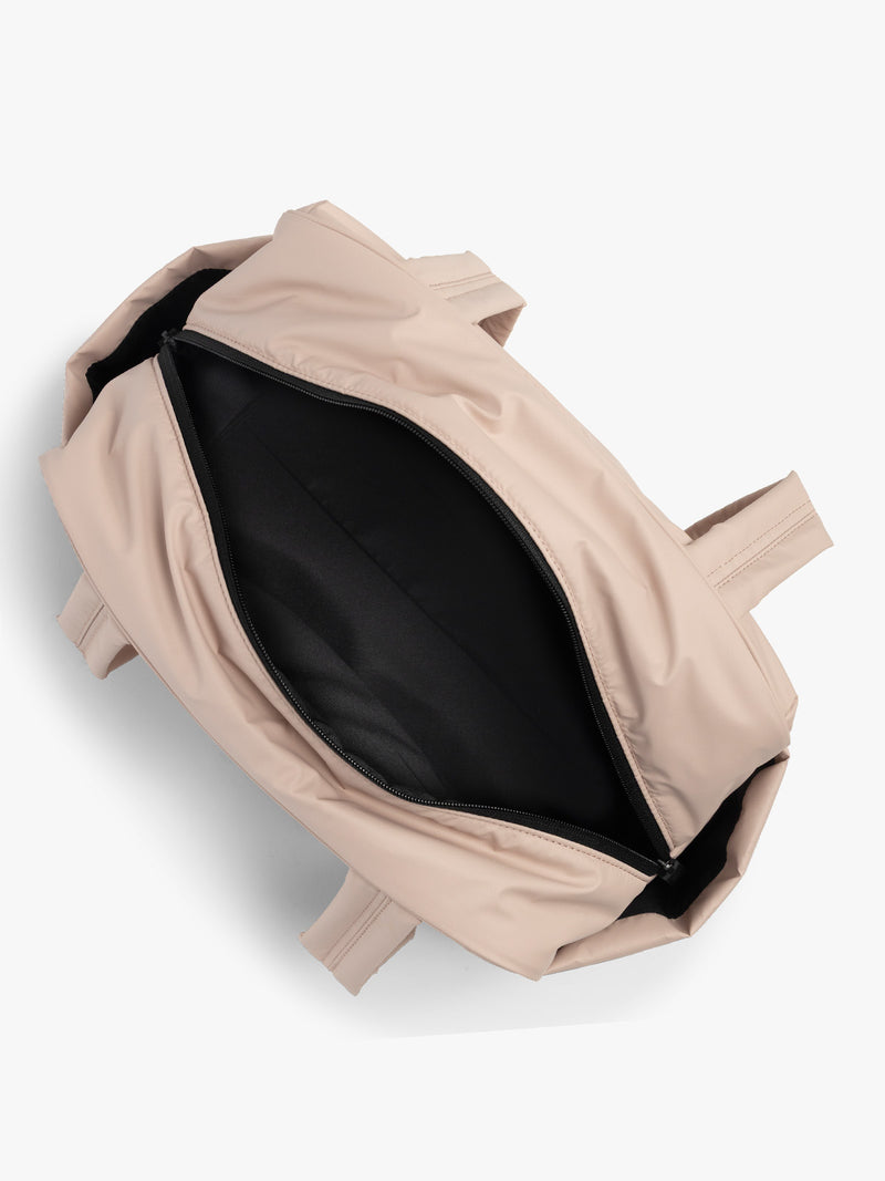 CALPAK Mini Duffel in light pink Rose Quartz open interior with puffy exterior, interior and exterior pockets, and padded shoulder straps