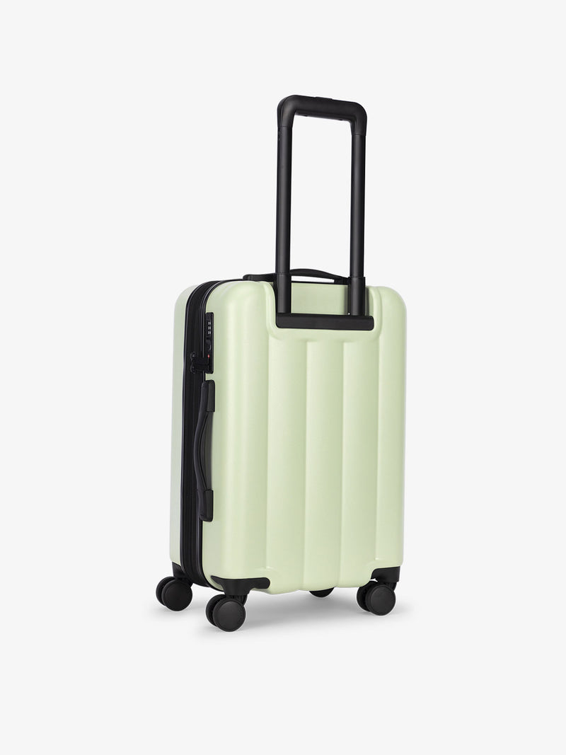 CALPAK carry-on luggage featuring dual spinner wheels and bottom grab handle in light green