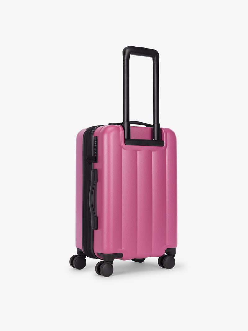 CALPAK carry-on luggage featuring dual spinner wheels and bottom grab handle in pinkish red