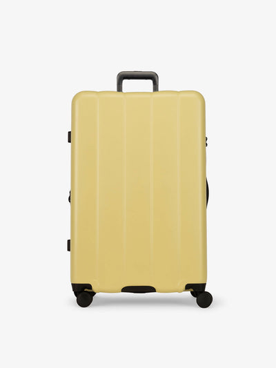 CALPAK yellow butter large luggage made from an ultra-durable polycarbonate shell and expandable by up to 2
