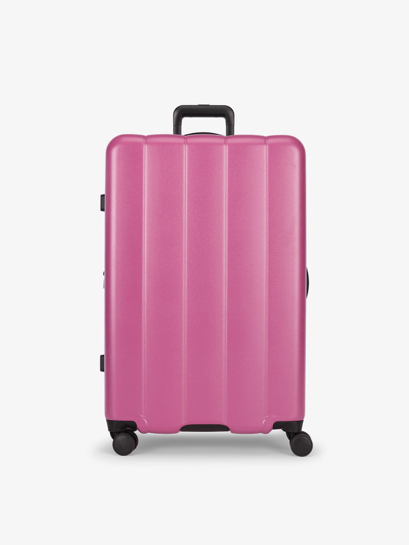 CALPAK raspberry large luggage made from an ultra-durable polycarbonate shell and expandable by up to 2"