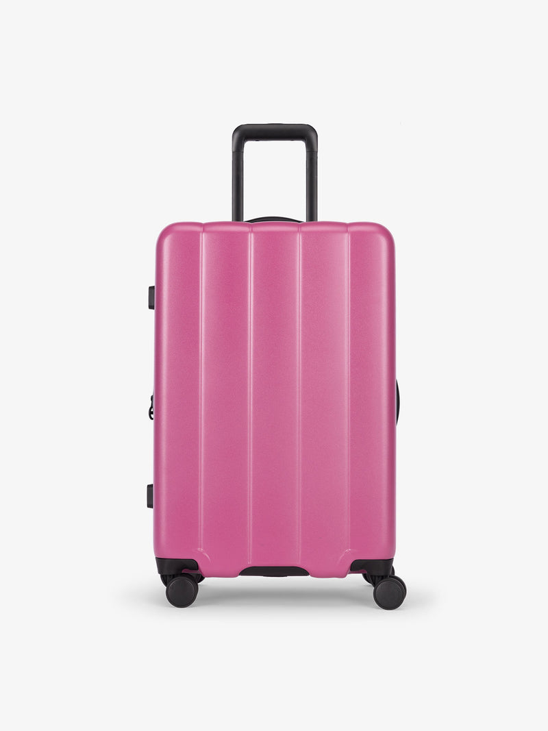 CALPAK raspberry medium luggage made from an ultra-durable polycarbonate shell and expandable by up to 2"