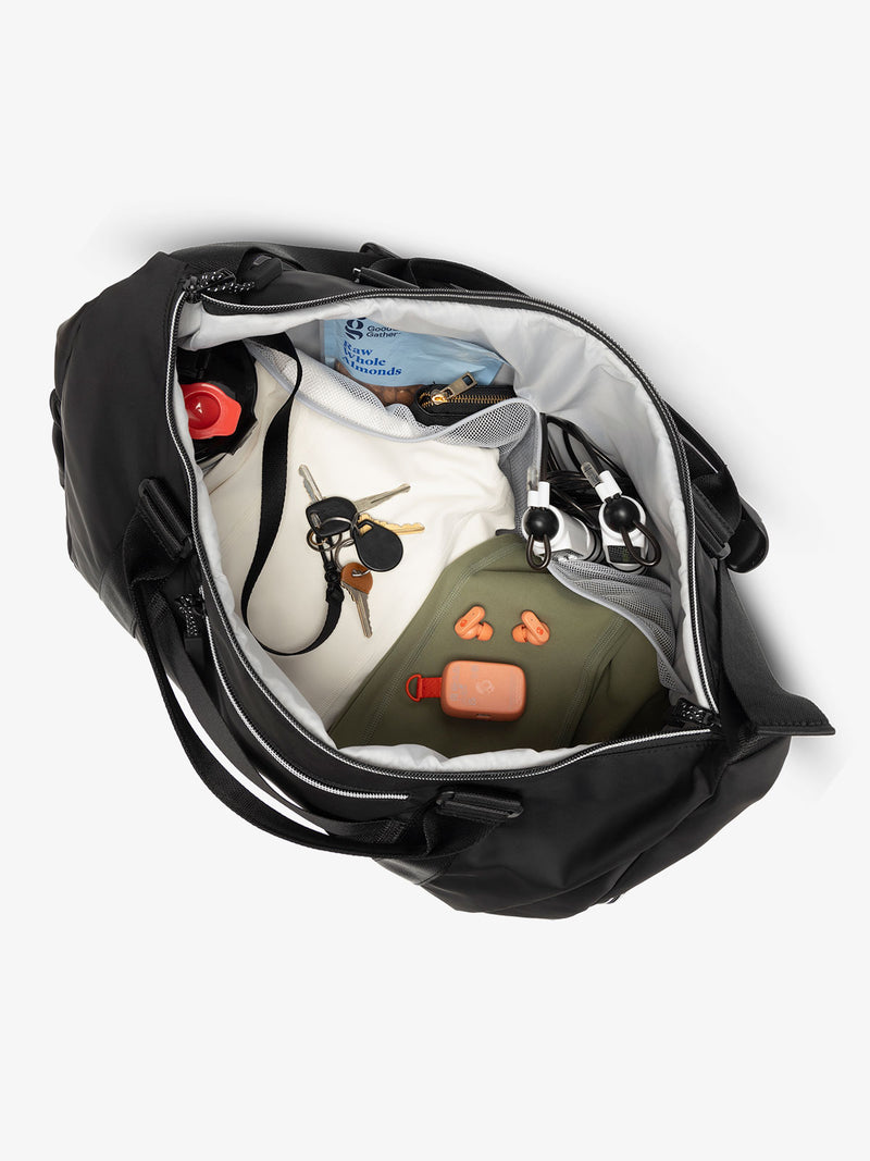 Interior view of black CALPAK Fit Gym Bag with personal belongings packed within