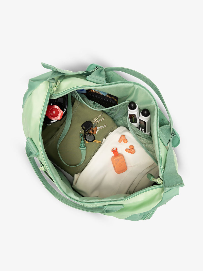 Interior view of green sage CALPAK Fit Gym Bag with personal belongings packed within