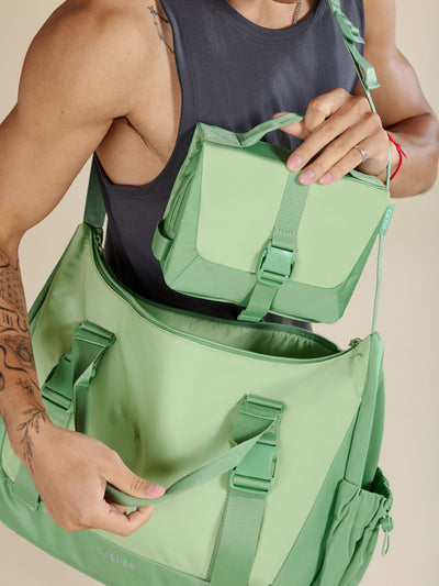 Front view of CALPAK Fit Hanging Dopp Kit made of recycled polyester and features a buckle front closure in sage; TFH2401-SAGE, TFH2401-SAGE-GRIN view 2