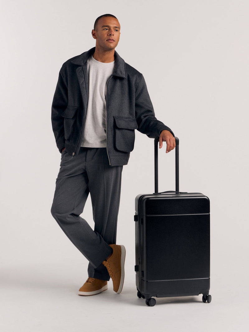 Model with CALPAK Hue Medium Hardside Luggage in black