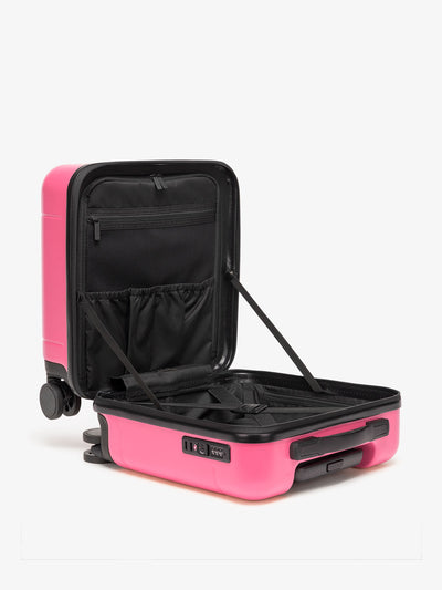 CALPAK Hue small carry-on featuring compression straps in hot pink