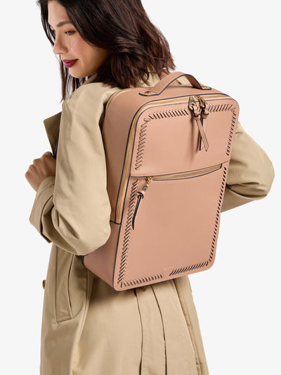 Model wearing brown CALPAK laptop backpack for 17 inch laptop