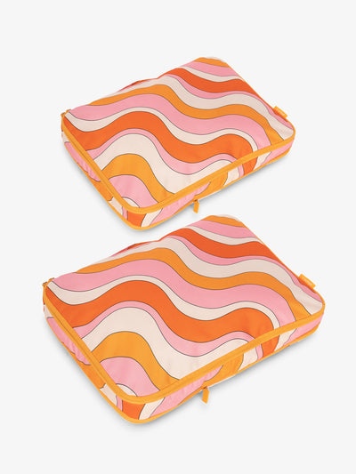 CALPAK Large Compression Packing Cubes in orange and pink wavy print; PCL2301-RETRO-SUNSET view 1