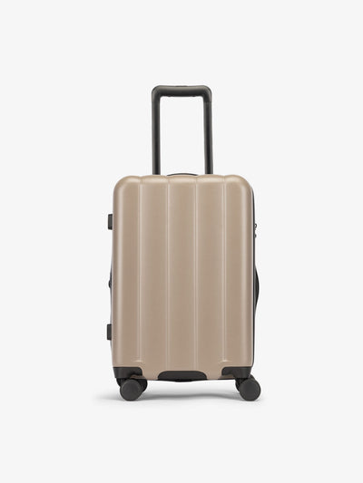 Brown chocolate CALPAK carry-on luggage made from an ultra-durable polycarbonate shell and expandable by up to 2"