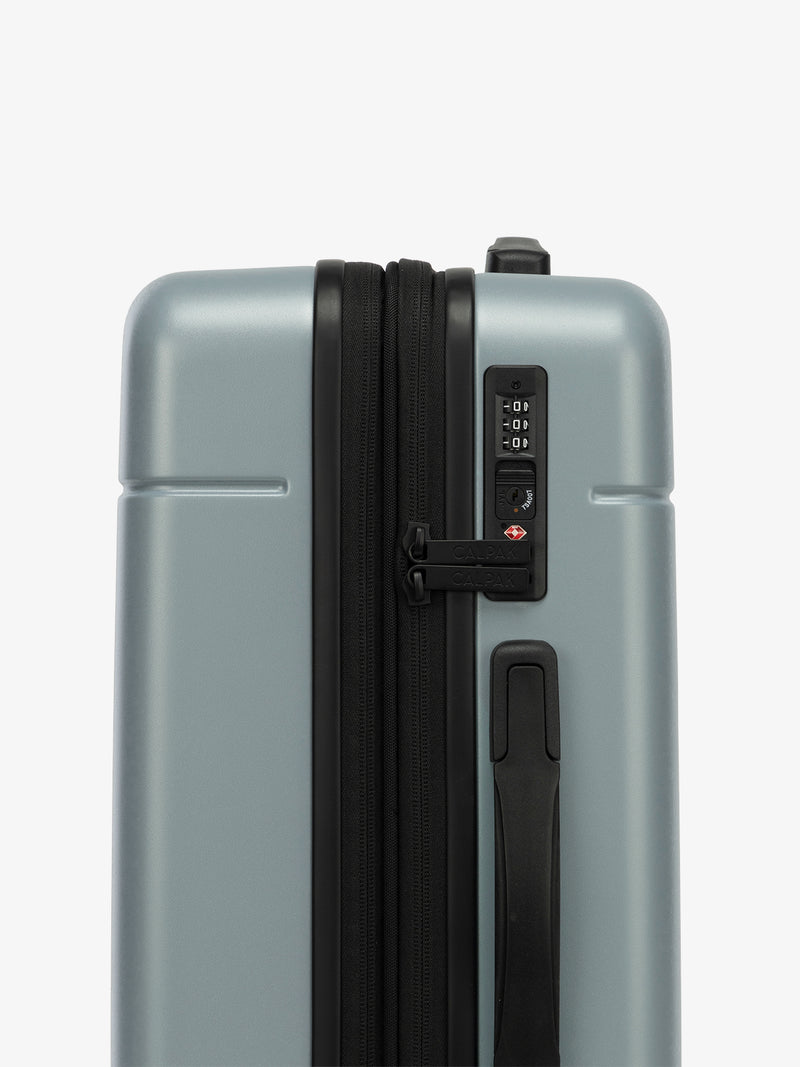 Side view of the CALPAK Hue Carry-On Luggage with the TSA-friendly lock in blue Bluebell