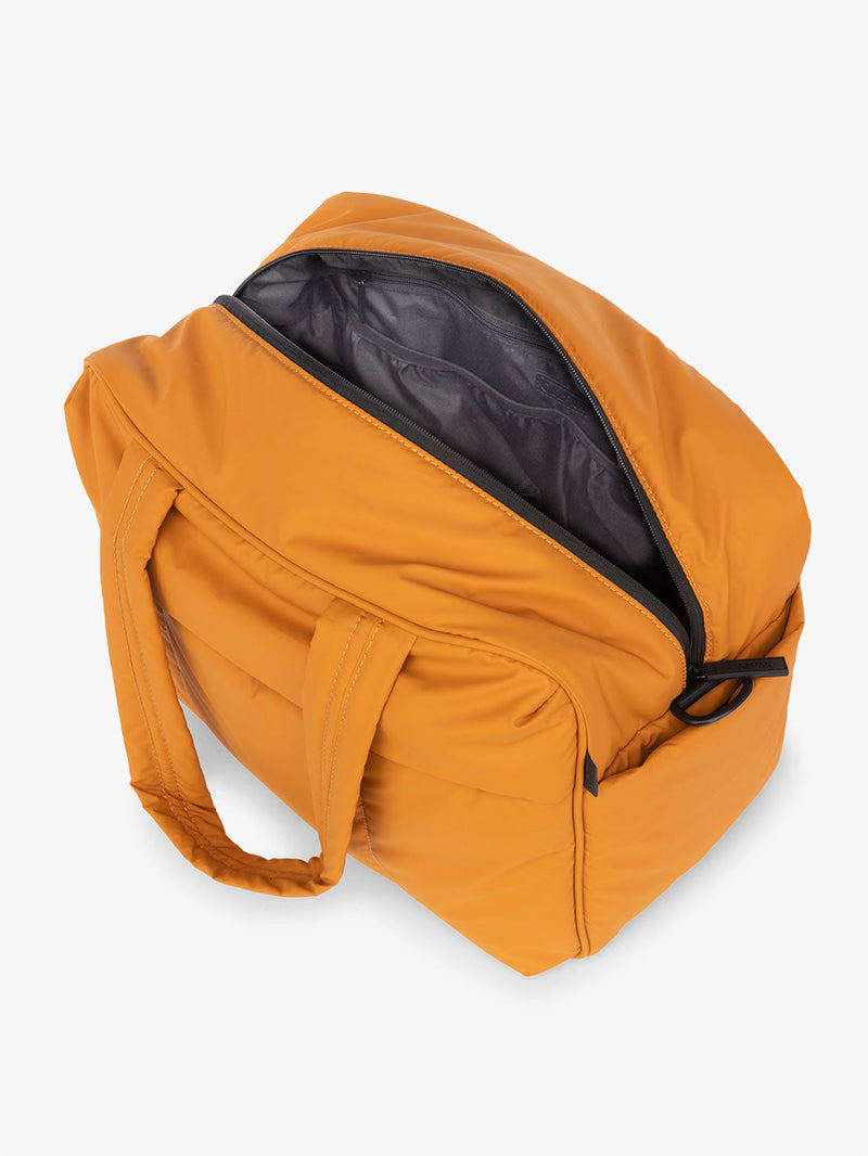 CALPAK Luka Duffel Bag open top view in pumpkin