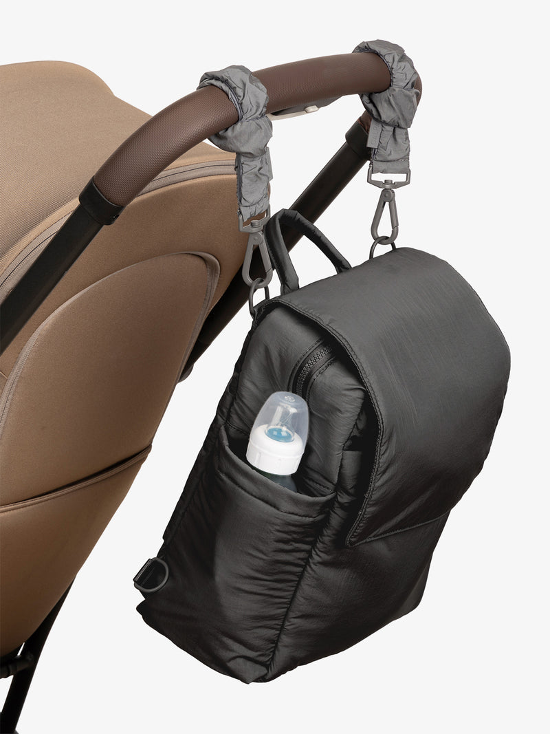 CALPAK Convertible Mini Diaper Backpack in Black with grey Slate Stroller Straps attached to a brown stroller