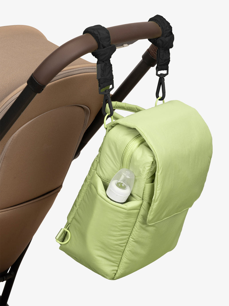 CALPAK Convertible Mini Diaper Backpack in light green Lime with Black Stroller Straps attached to a brown stroller