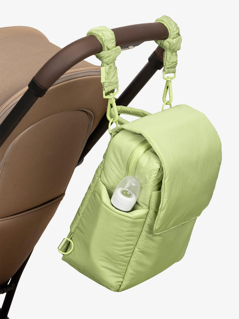 CALPAK Convertible Mini Diaper Backpack in light green Lime with light green Stroller Straps attached to a brown stroller