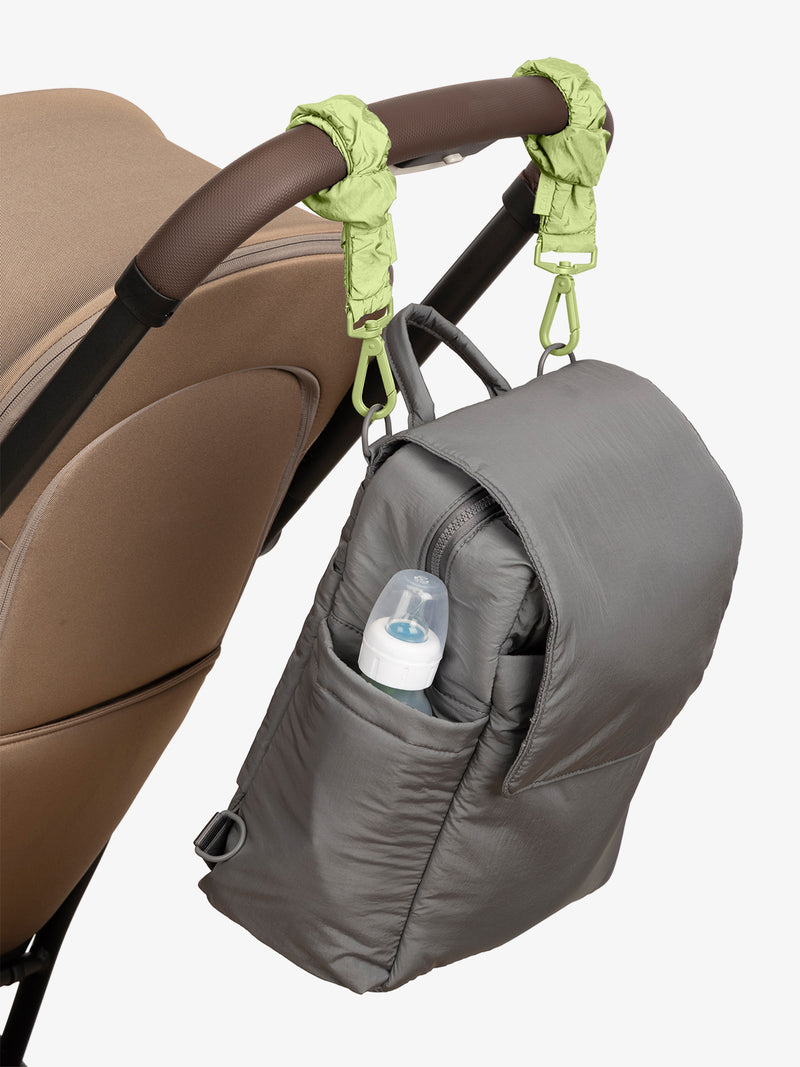 CALPAK Convertible Mini Diaper Backpack in grey Slate with light green Lime Stroller Straps attached to a brown stroller