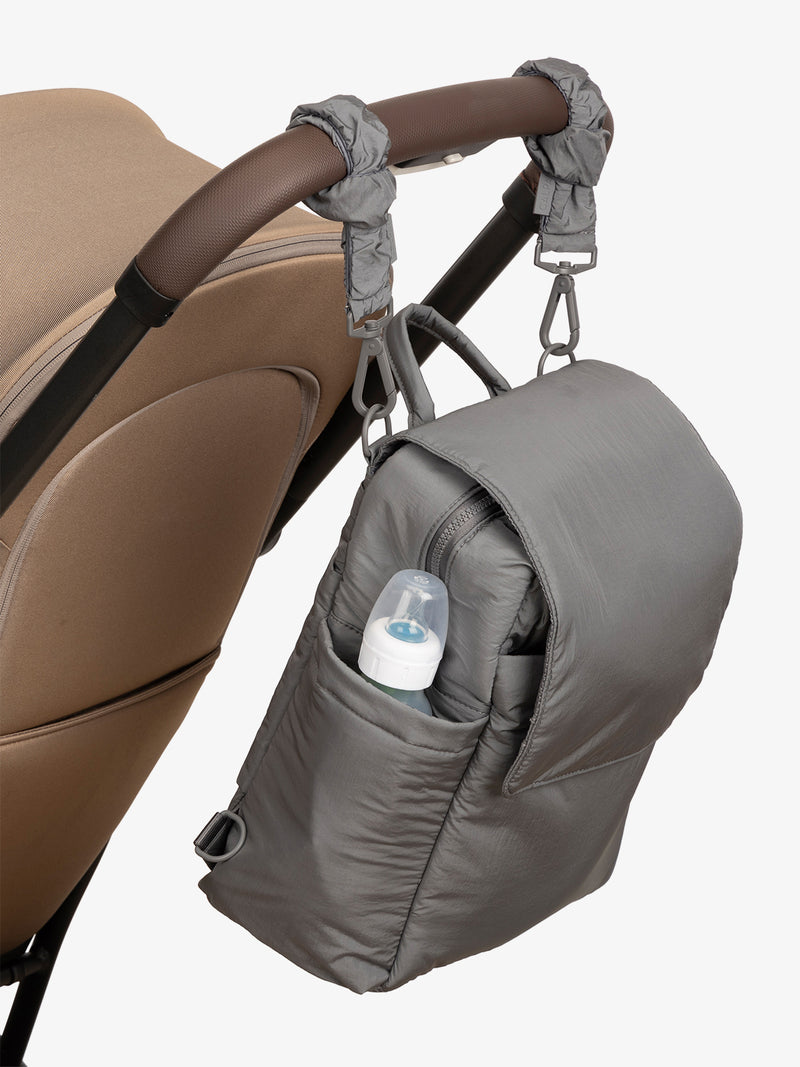 CALPAK Convertible Mini Diaper Backpack in grey Slate with grey Slate Stroller Straps attached to a brown stroller