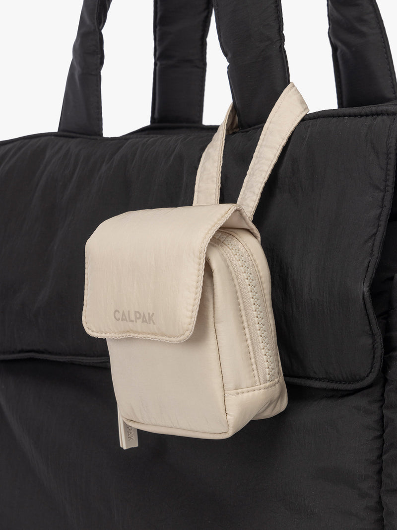 CALPAK Baby Collection Pacifier Pouch in white Oatmeal clipped onto black bag