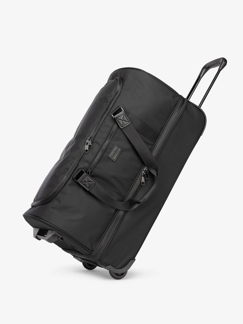 Side view of CALPAK Stevyn Large Rolling Duffel in black