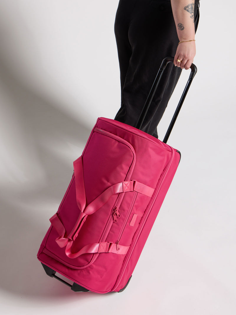 Model rolling CALPAK Stevyn Large Rolling Duffel in dragonfruit