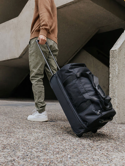 CALPAK Stevyn Rolling Duffel side view in black; DSR2201-BLACK view 2