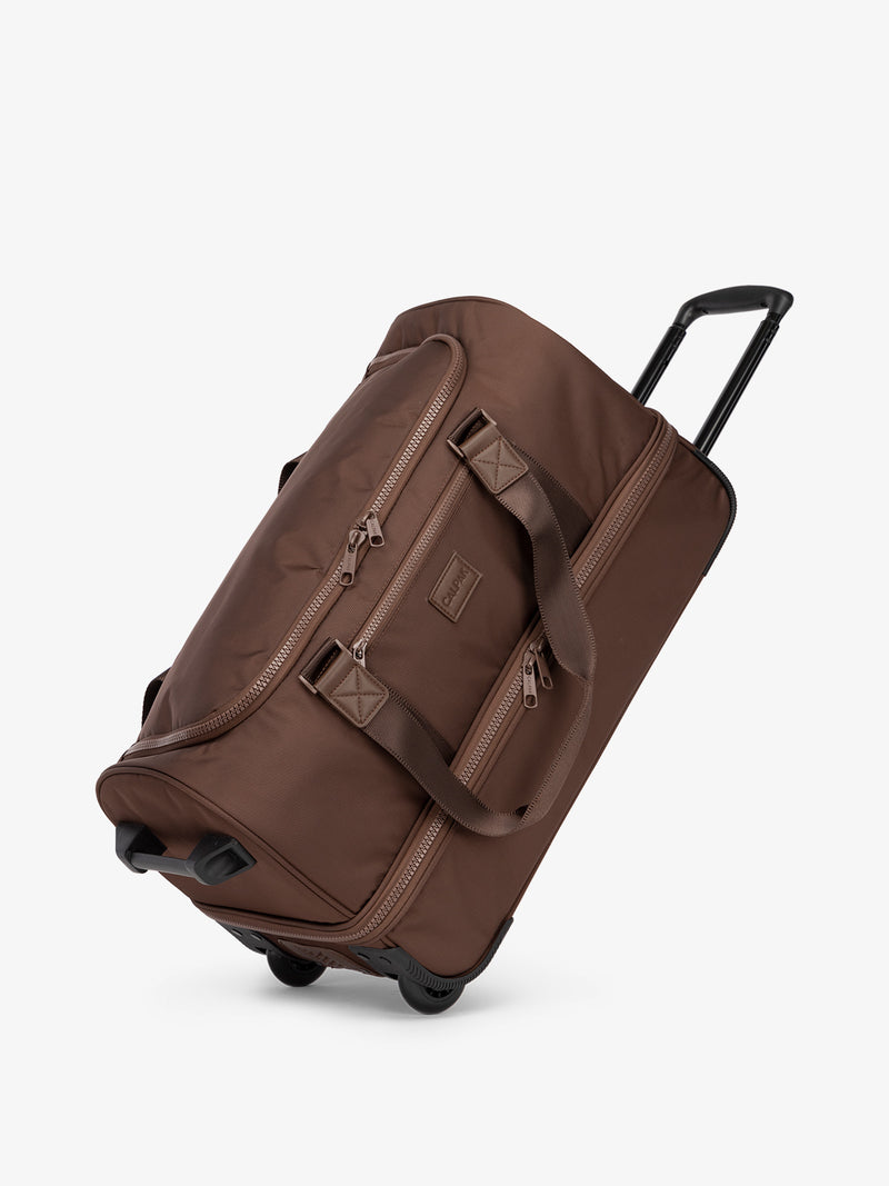 CALPAK Stevyn Rolling Duffel side view with top handle extended in walnut