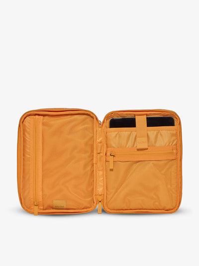 Interior of tablet organizer with zippered pockets and padded tablet sleeve in orange grid by CALPAK