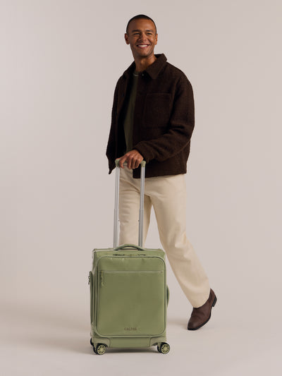 Studio product shot of back-facing CALPAK Terra 35L Carry-On luggage with soft shell and 360 spinner wheels in olive green juniper; LTR1020-JUNIPER view 2