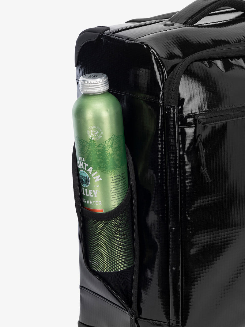 Studio product shot of side bottle holder pocket of CALPAK Terra 35L Carry-On luggage with soft shell and 360 spinner wheels in black obsidian