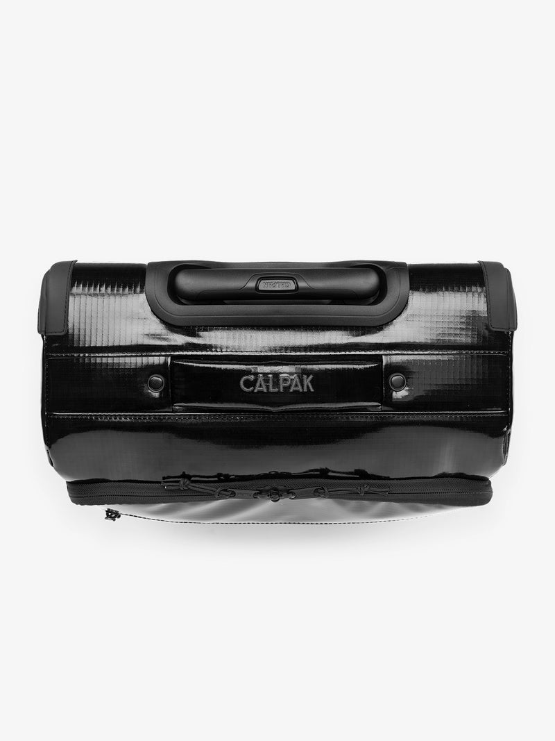 Studio product shot of top handle of CALPAK Terra 35L Carry-On luggage with soft shell and 360 spinner wheels in obsidian black