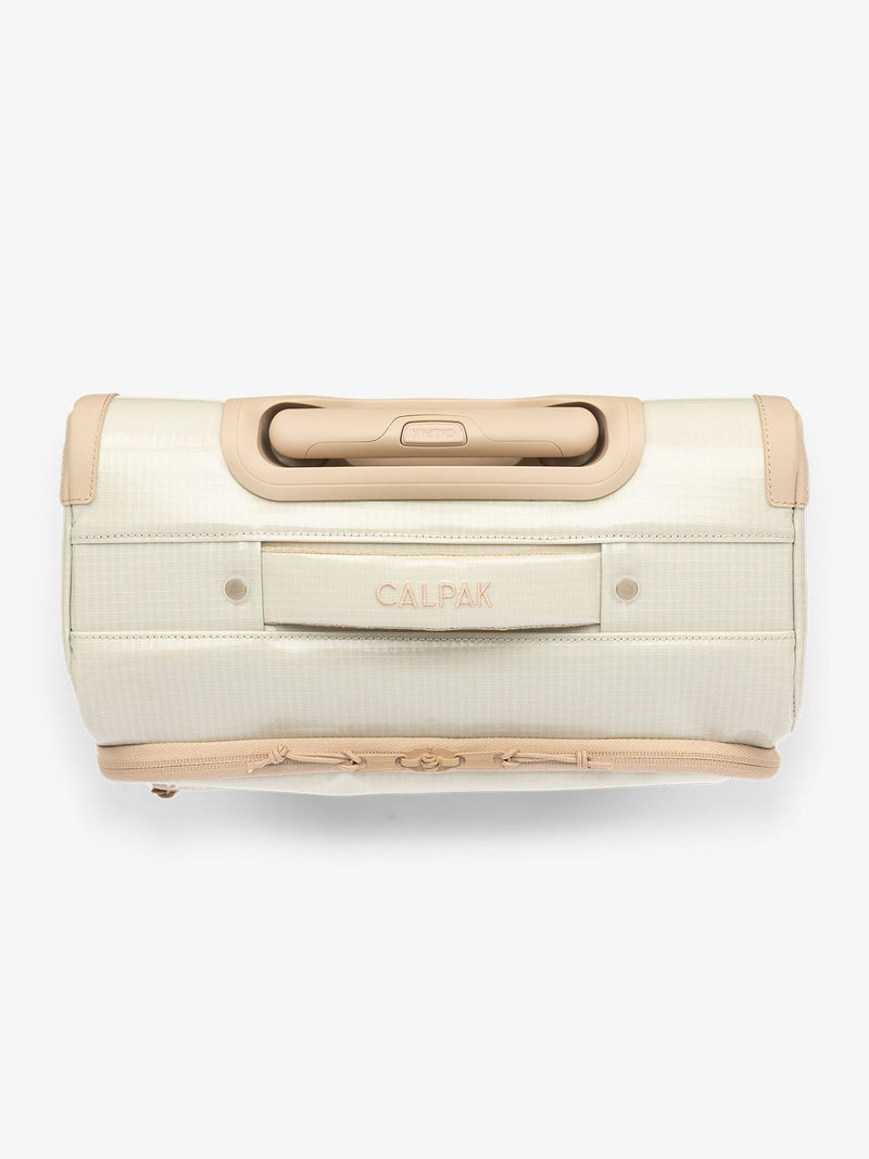 Studio product shot of top handle of CALPAK Terra 35L Carry-On luggage with soft shell and 360 spinner wheels in white sands