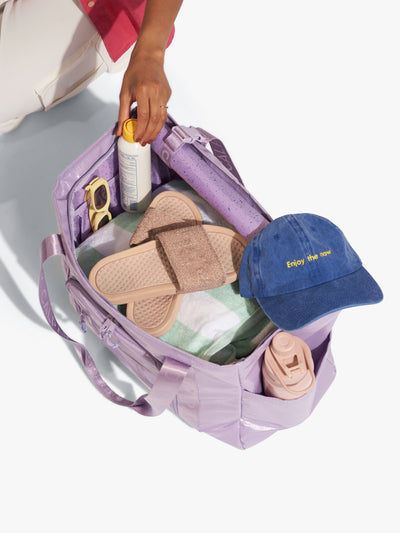 CALPAK Terra 35L Water Resistant Zippered Tote Bag interior full of items for the beach in purple