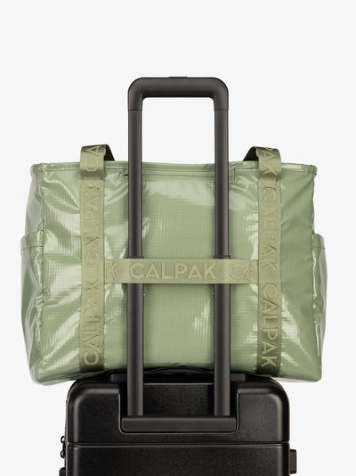 Luggage trolley sleeve of CALPAK Terra 35L Water Resistant Zippered Tote Bag in juniper