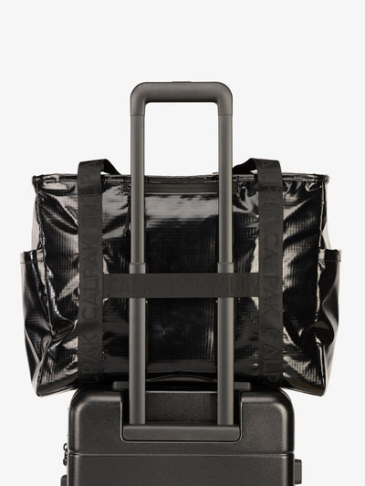Luggage trolley sleeve of CALPAK Terra 35L Water Resistant Zippered Tote Bag in obsidian